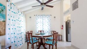A dining area with a round table, six chairs, and a ceiling fan. - Cozy 2-Bedrooms across from West Coast beach (St James)