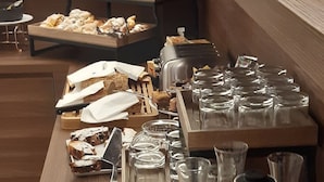 En frukostbuffé med ett urval av bakverk, bröd och drycker.