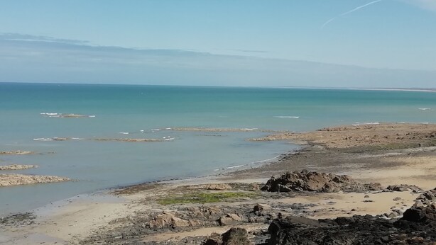 Eine Küstenlandschaft mit felsigem Gelände und ruhigem Wasser.