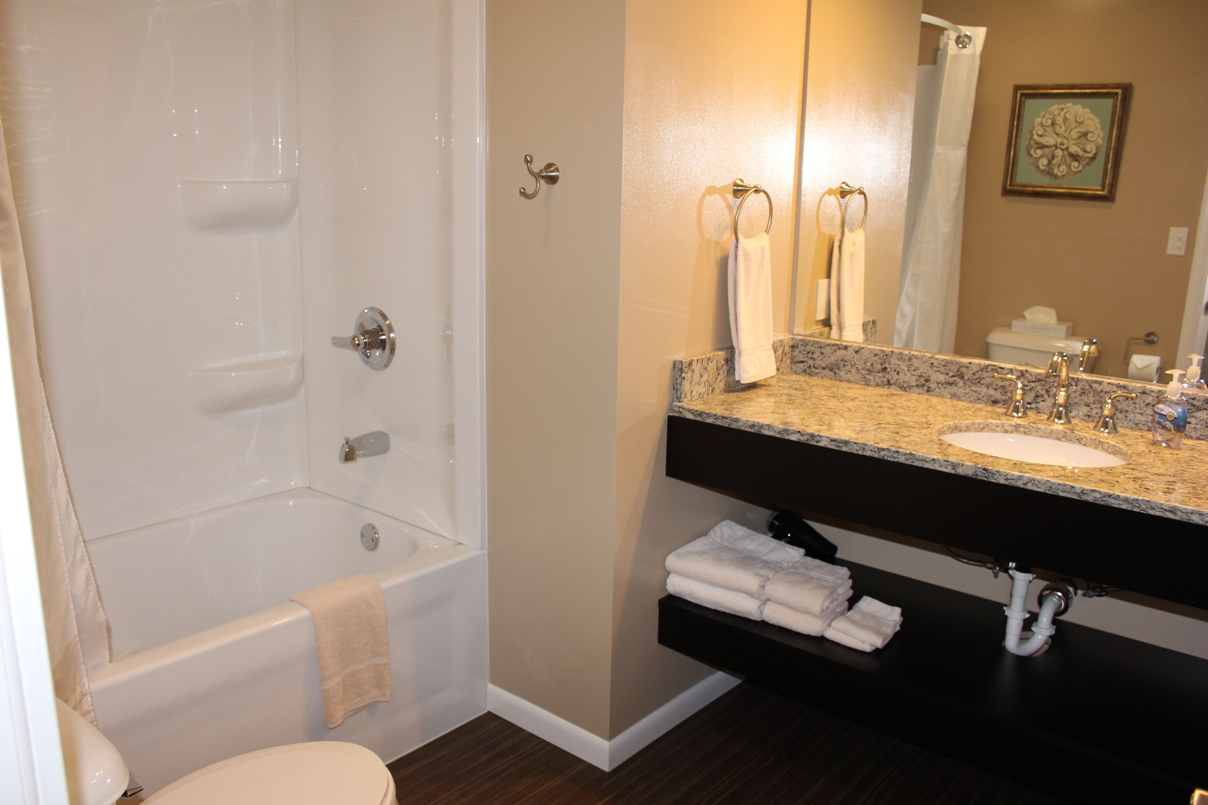 A bathroom with a bathtub, a sink with a vanity, and a toilet.