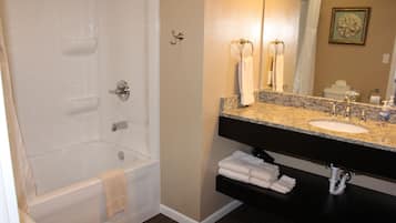 A bathroom with a bathtub, a sink with a vanity, and a toilet.