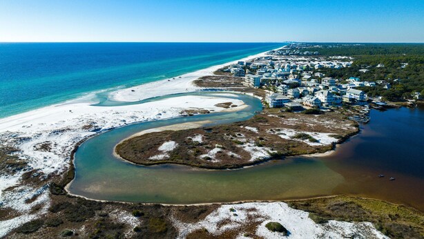 An aerial view of a coastal area with a beach, a river, and a residential area with houses. - Prime Location Near Community Pool | 6 Beach Bikes | Tram to Easy Beach Access (Santa Rosa Beach)
