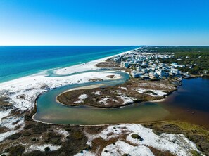 An aerial view of a coastal area with a beach, a river, and a residential area with houses. - Prime Location Near Community Pool | 6 Beach Bikes | Tram to Easy Beach Access (Santa Rosa Beach)