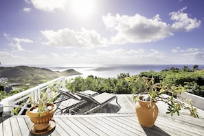 Relax in a tranquil outdoor space with ocean views and distant hills.