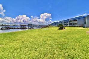 A hotel with a grassy lawn, a dock, and a body of water.