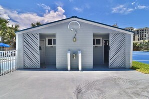 A small building with a gabled roof, two doors, and a small window. - A 13 Sundown Condominiums (Pensacola)