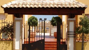 A gated entrance with a tiled roof, a staircase leading to a building, and a sign indicating private property. - Dream vacation in Islantilla (Lepe)