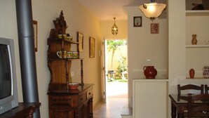 A living room with a fireplace, wooden furniture, and a dining area with chairs and a table. - Dream vacation in Islantilla (Lepe)