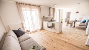 Un salon moderne comprenant un canapé, un coin repas et une cuisine.