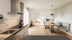 Une cuisine moderne équipée d’une cuisinière intégrée, d’une machine à café et d’un évier.