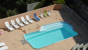 An outdoor swimming pool with multiple lounge chairs arranged around it. - Propriano T3 50 m2 - magnificent view of the Gulf of Valinco and swimming pool (Propriano)
