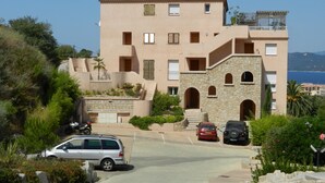 A multi-story building with a stone facade, balconies, and a view of the sea. - Propriano T3 50 m2 - magnificent view of the Gulf of Valinco and swimming pool (Propriano)