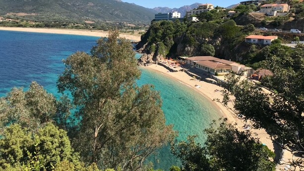 A coastal area with a beach, buildings, and mountains in the background. - Propriano T3 50 m2 - magnificent view of the Gulf of Valinco and swimming pool (Propriano)