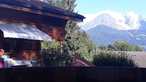 Uma cabana de madeira com vista para montanhas cobertas de neve.