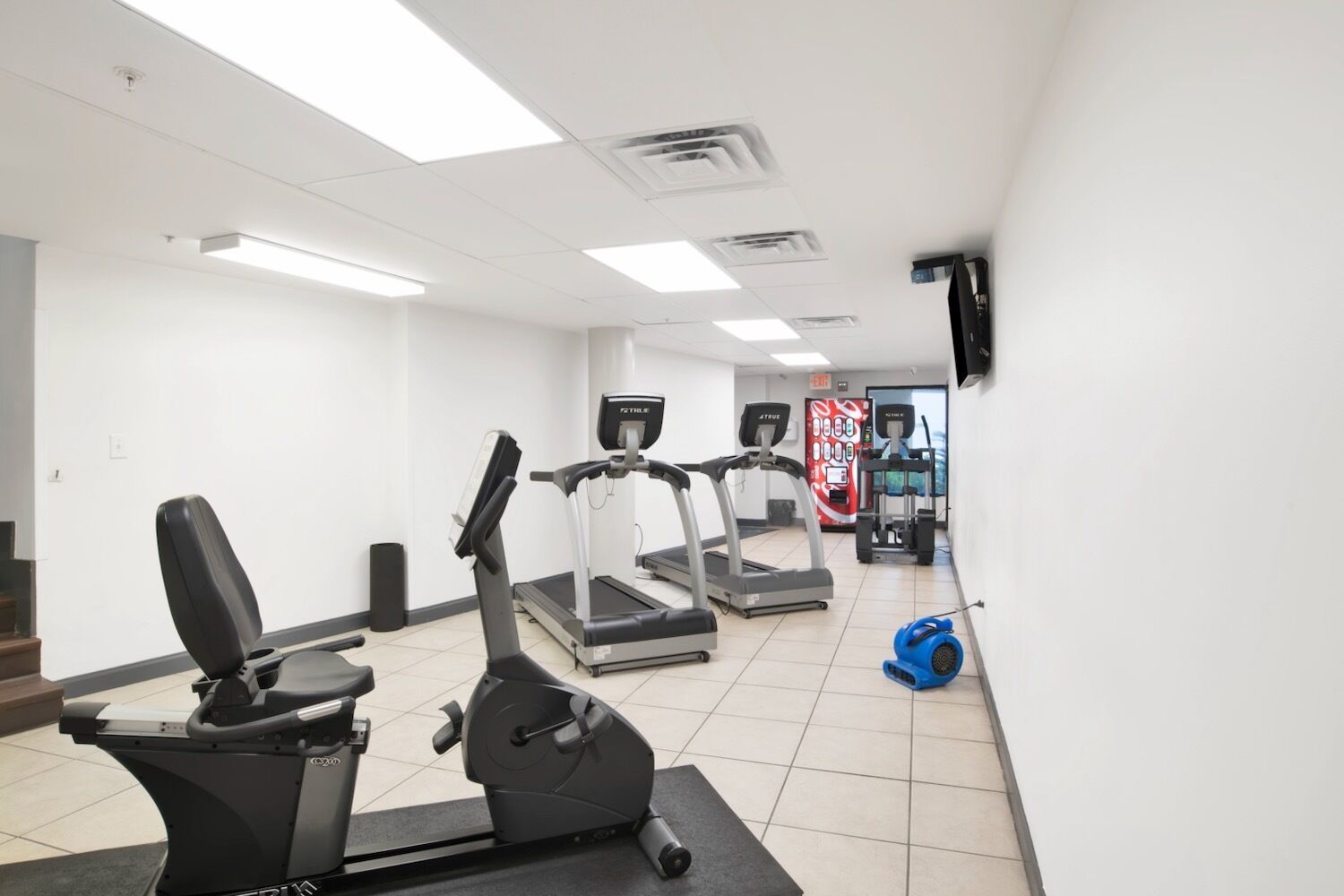 A gym with treadmills, an elliptical, and a stationary bike.