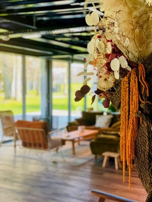 Un área de estar interior acogedora con piso de madera, sillas acolchadas y una mesa.
