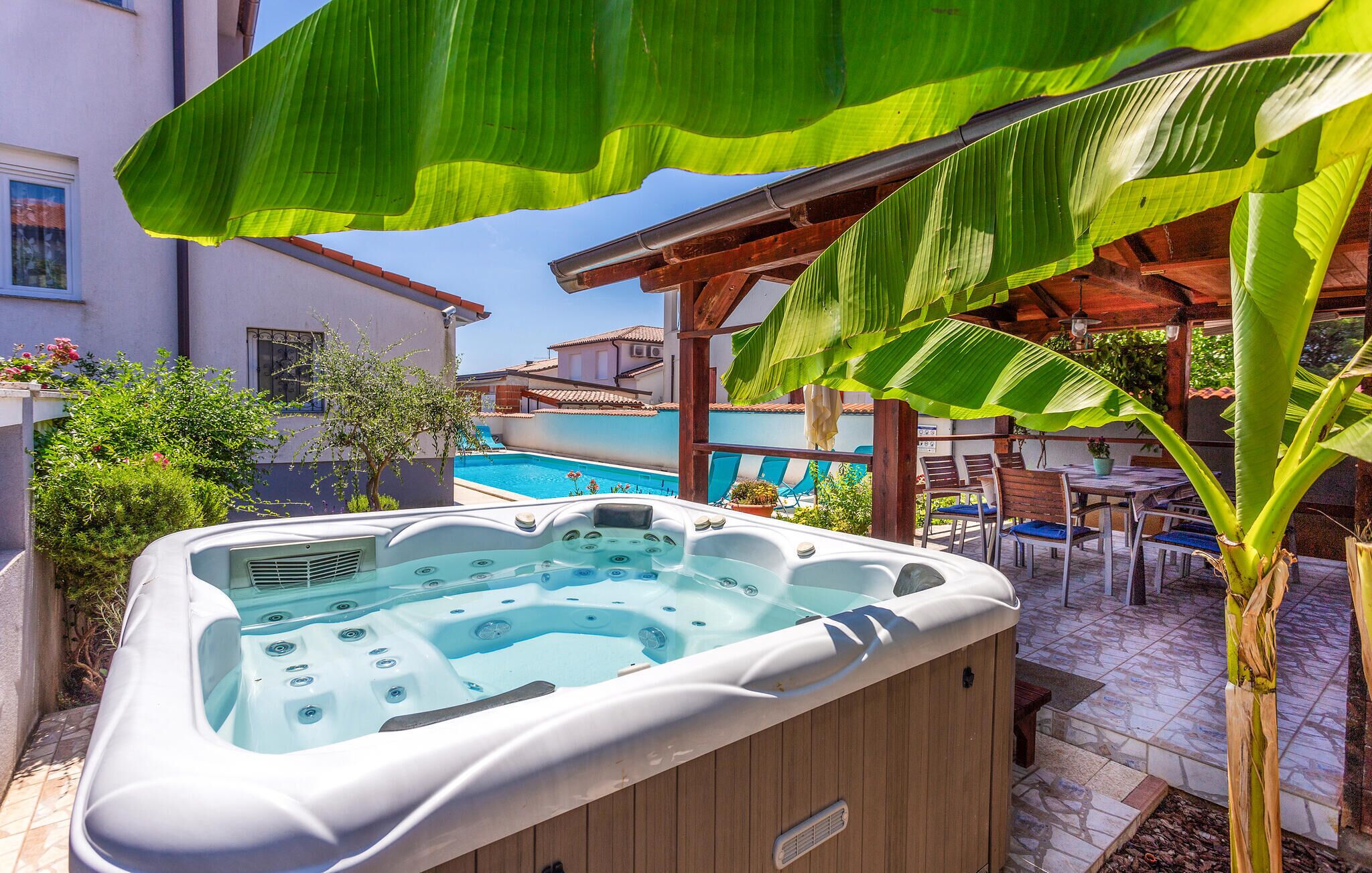 A hot tub area with a pool and outdoor seating.