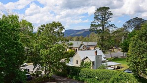 A residential area with houses, a road, and a mountain in the background. - Cloudsong Chalet 1 - Close to the village centre! (Kangaroo Valley)