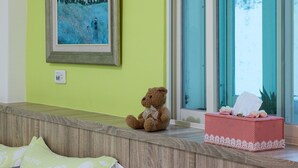 A room with a wooden bench, a teddy bear, a tissue box, and a painting on the wall. - Yi-Jing B&B (Hualien City)