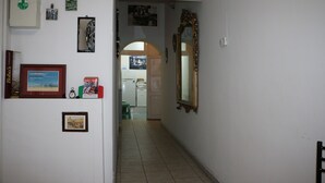 A hallway with a refrigerator, framed pictures, and a mirror. - Roman Place (Rome)