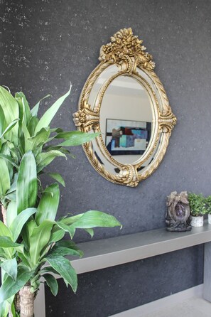 A mirror with an ornate gold frame on a dark wall. - Lâviu B&B Luxe Suites (San Andrés Cholula)