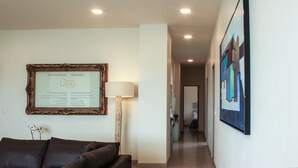 A hallway with a framed welcome sign, a lamp, and a painting on the wall. - Lâviu B&B Luxe Suites (San Andrés Cholula)