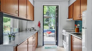 A compact kitchen with wooden cabinets, a built-in oven, and a coffee maker. - Awesome home in Knebel with kitchen (Knebel)