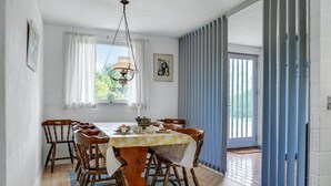 A dining room with a wooden table, chairs, a chandelier, and a view of the outdoors. - Awesome home in Knebel with kitchen (Knebel)