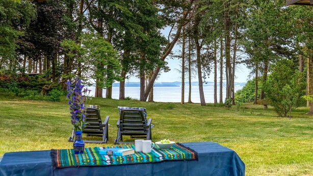 A table set outdoors with a view of the water and trees. - Awesome home in Knebel with kitchen (Knebel)