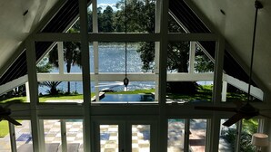 Una habitación con suelo de cuadros, piscina y vista a un lago.
