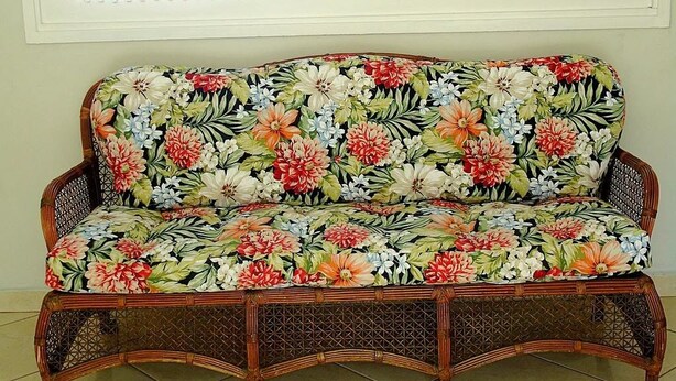 A wicker sofa with a floral fabric pattern. - Pousada Xamã Tour (João Pessoa)