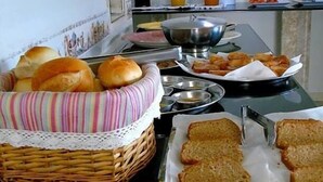 A breakfast buffet with bread, pastries, and beverages. - Pousada Xamã Tour (João Pessoa)