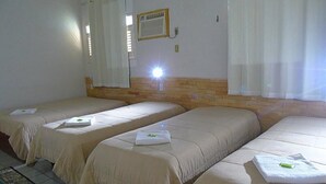 A hotel room with three single beds, each with a white bedspread and a towel. - Pousada Xamã Tour (João Pessoa)