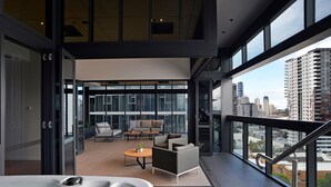 A modern balcony with a hot tub, seating area, and city views. - Brisbane One Apartments by CLLIX (South Brisbane)