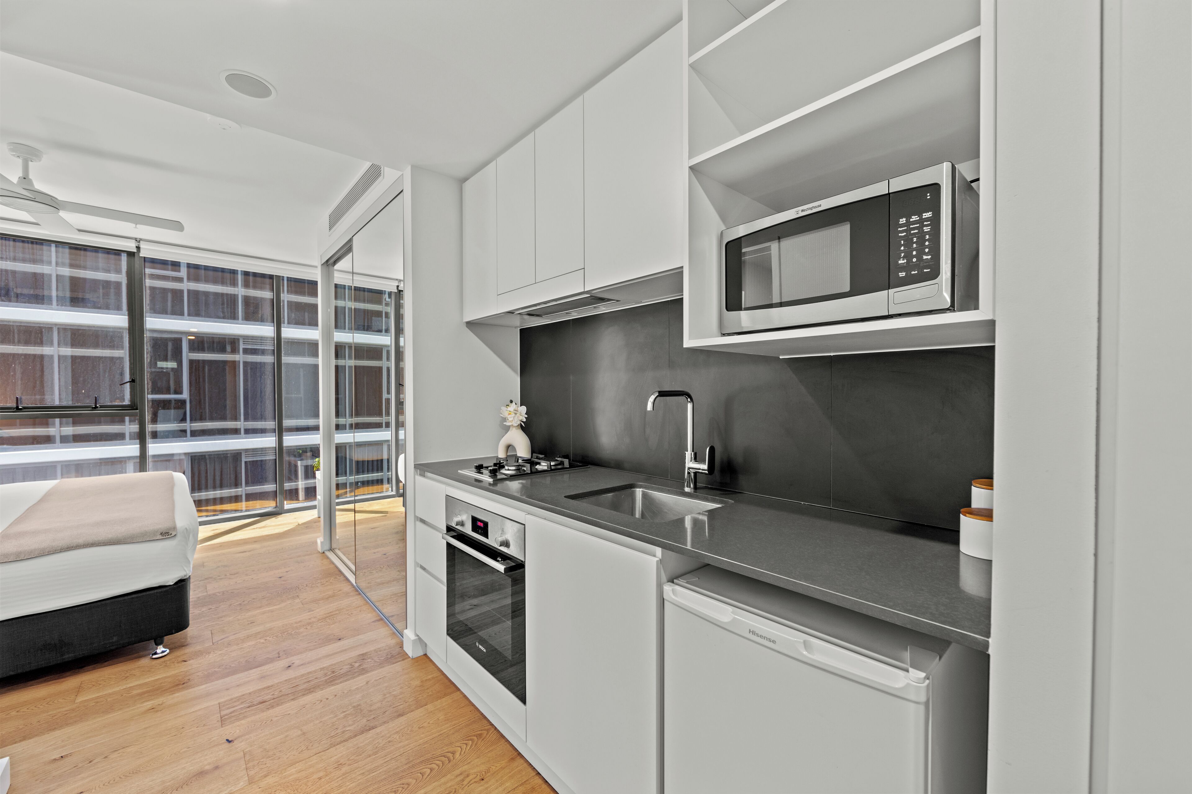 A modern kitchen with white cabinetry, a built-in microwave, and a dishwasher.