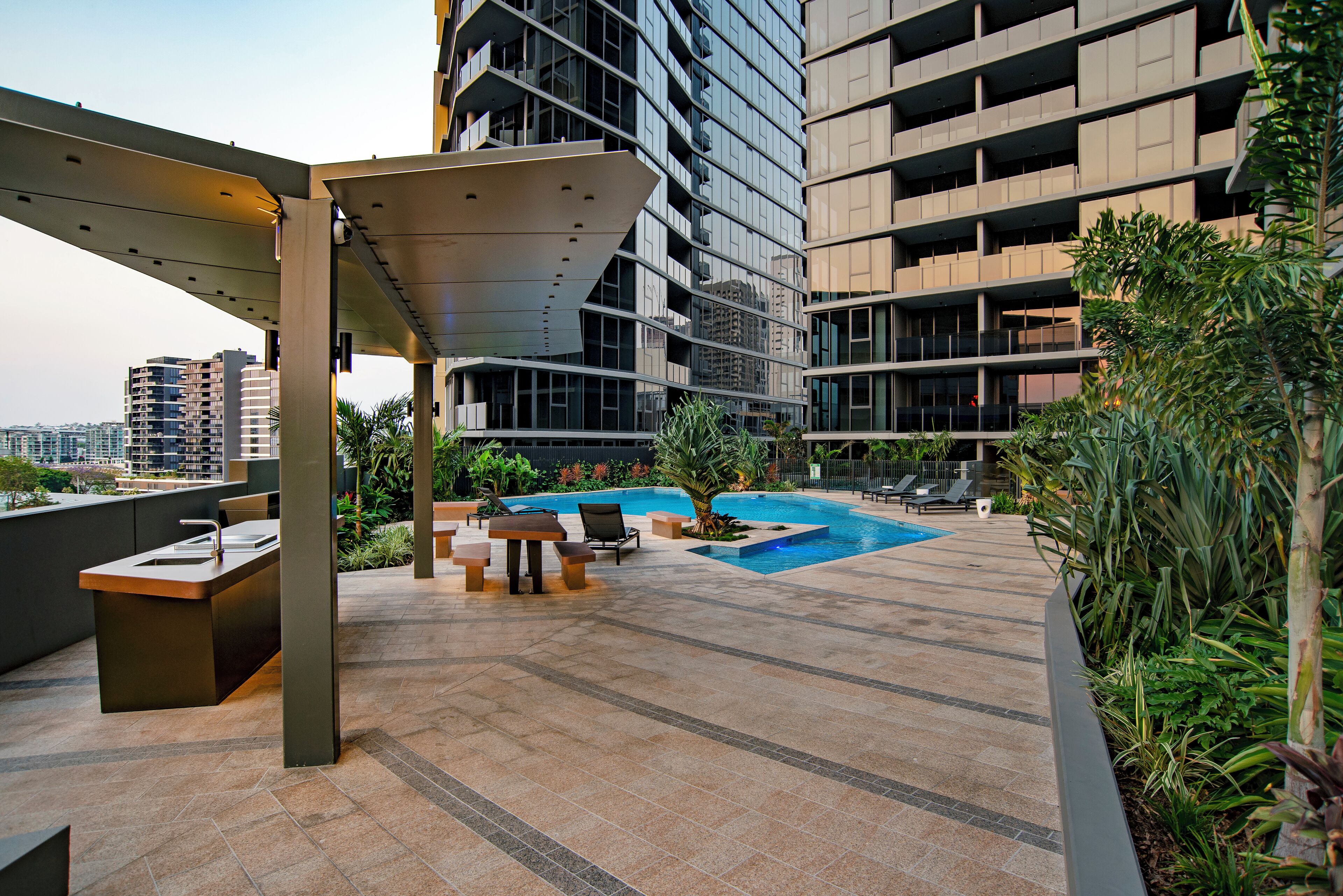A rooftop pool area with a modern design, including a pool, lounge chairs, and a seating area.