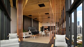 A modern interior with a dining area, seating, and a kitchen. - Brisbane One Apartments by CLLIX (South Brisbane)
