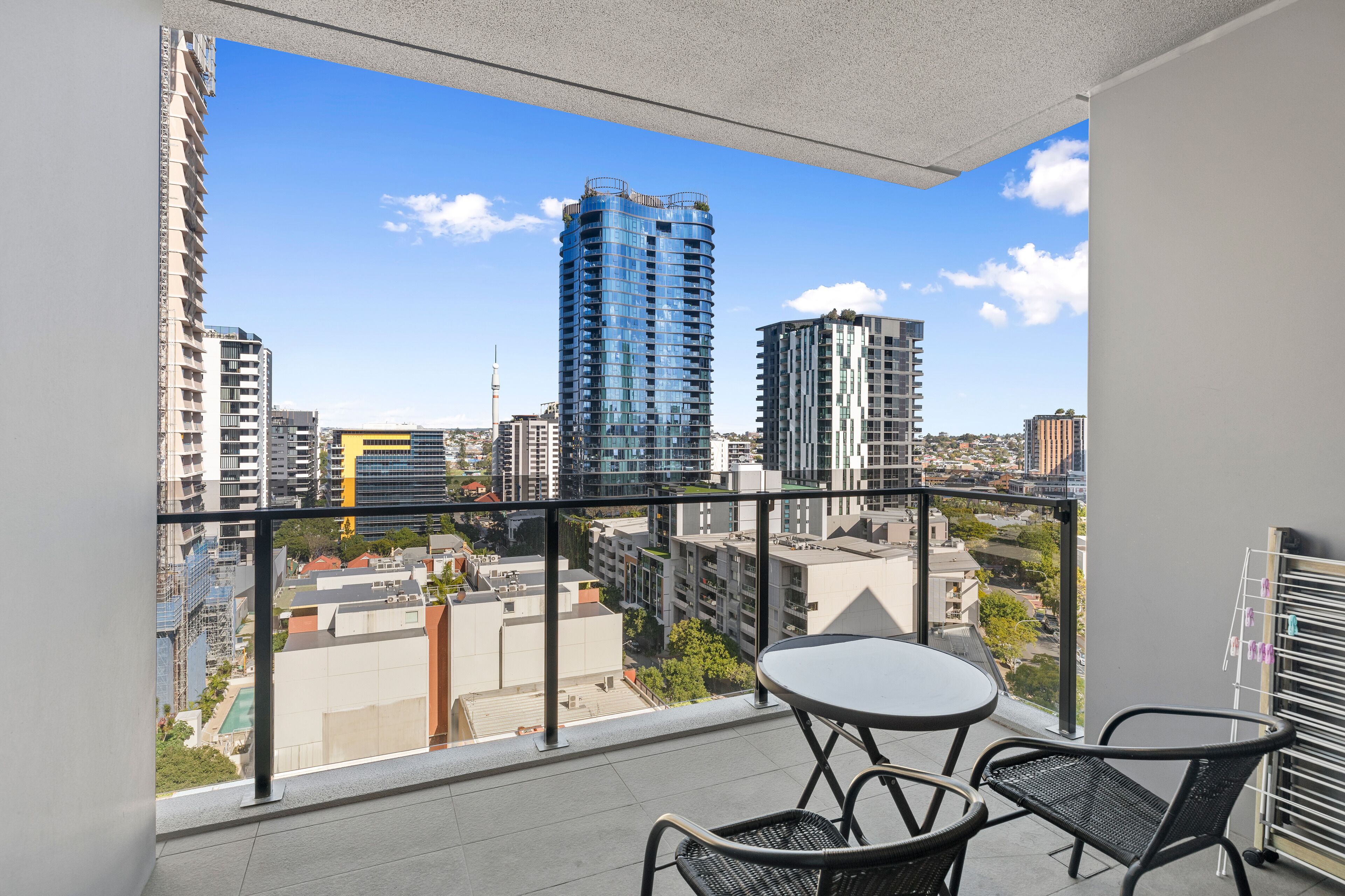 Un balcon avec vue sur la ville, une table et des chaises.