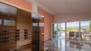 A modern interior with a glass door leading to an outdoor seating area with a view of the countryside. - Lovely home in Donji Prolozac with sauna (Donji Prolozac)