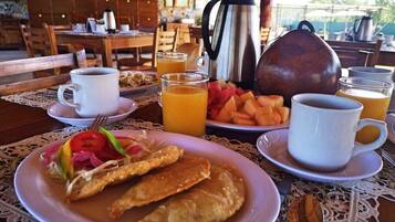 Una escena de desayuno con platos de comida, café y jugo.