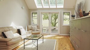 A living room with a sofa, a glass coffee table, and a cabinet. There are large windows with a view of trees and a lawn. - Cloud Nine Chalet - Luxury retreat in Upper River! (UPPER KANGAROO RIVER)