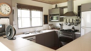 A modern kitchen with a microwave, stove, and various utensils. - Cloud Nine Chalet - Luxury retreat in Upper River! (UPPER KANGAROO RIVER)