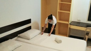 Une chambre d’hôtel avec deux lits, un bureau et une armoire.