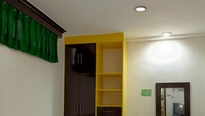 Une chambre d’hôtel avec un lit, un bureau, une chaise et un miroir.
