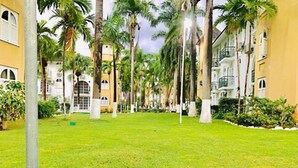 Een binnentuin met palmbomen en een gebouw met balkons.