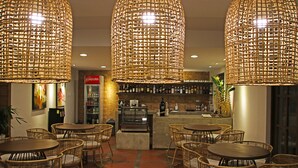A bar area with wicker chairs and hanging wicker lamps. - Balai Princesa (Puerto Princesa)