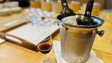 Una mesa con una botella de vino, una copa de vino y una bandeja con copas.