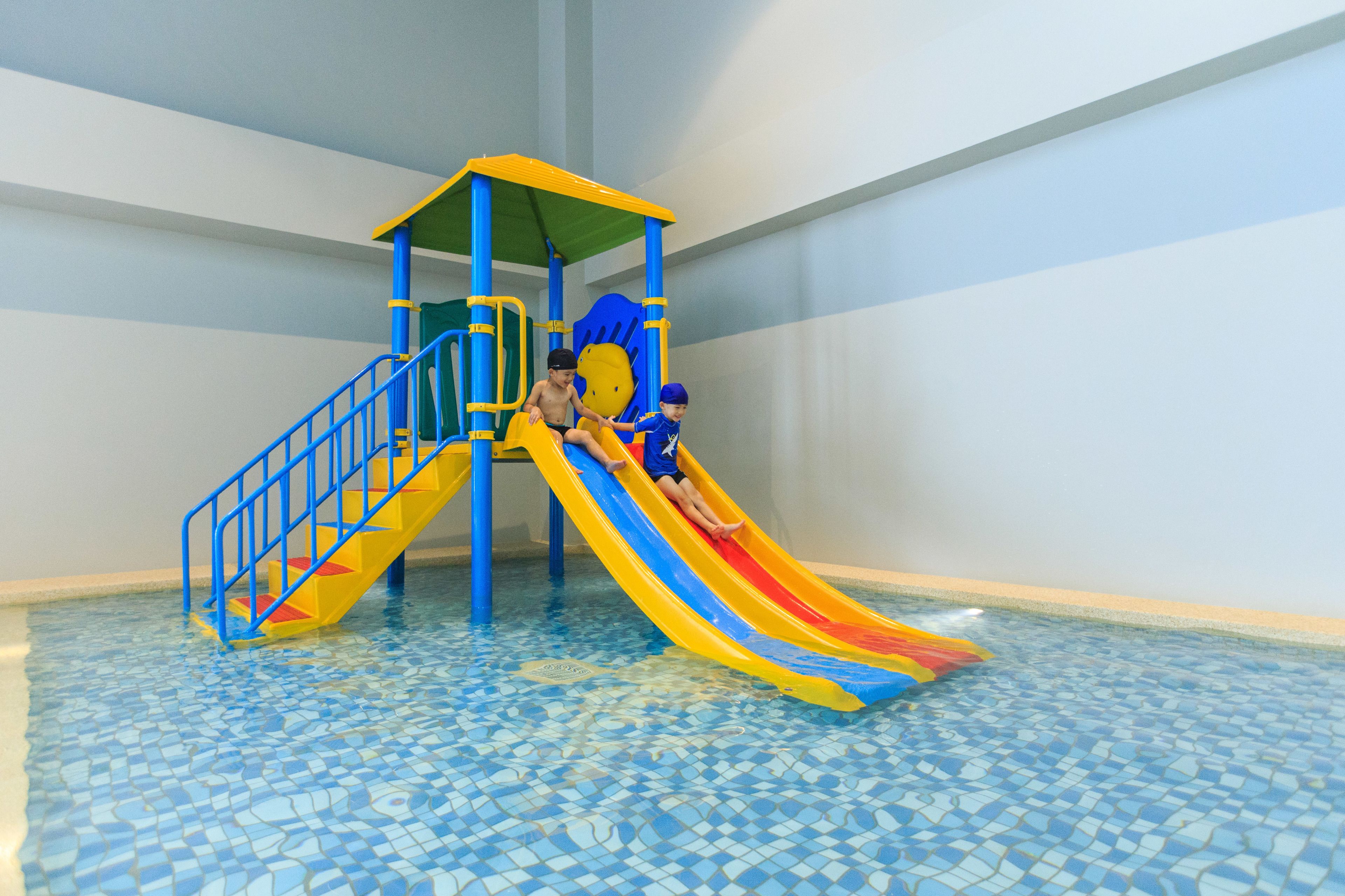 Zona de jocs infantil amb tobogan i estructura per escalar.