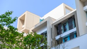 A multi-story building with a modern architectural design, featuring balconies and large windows. - Hotel PIN Jiaoxi (Jiaoxi)