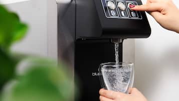 A water dispenser with a hand pressing a button.